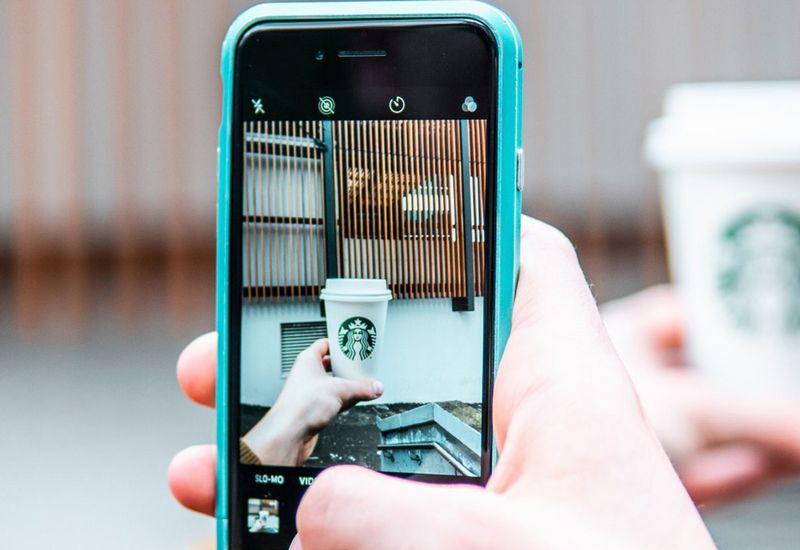 Uma pessoa usando Google Lens para filmar um compo de café da StarBucks.