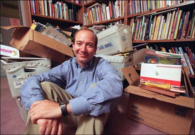 Jeff Bezos em meio a uma montanha de livros quando começou a Amazom.com