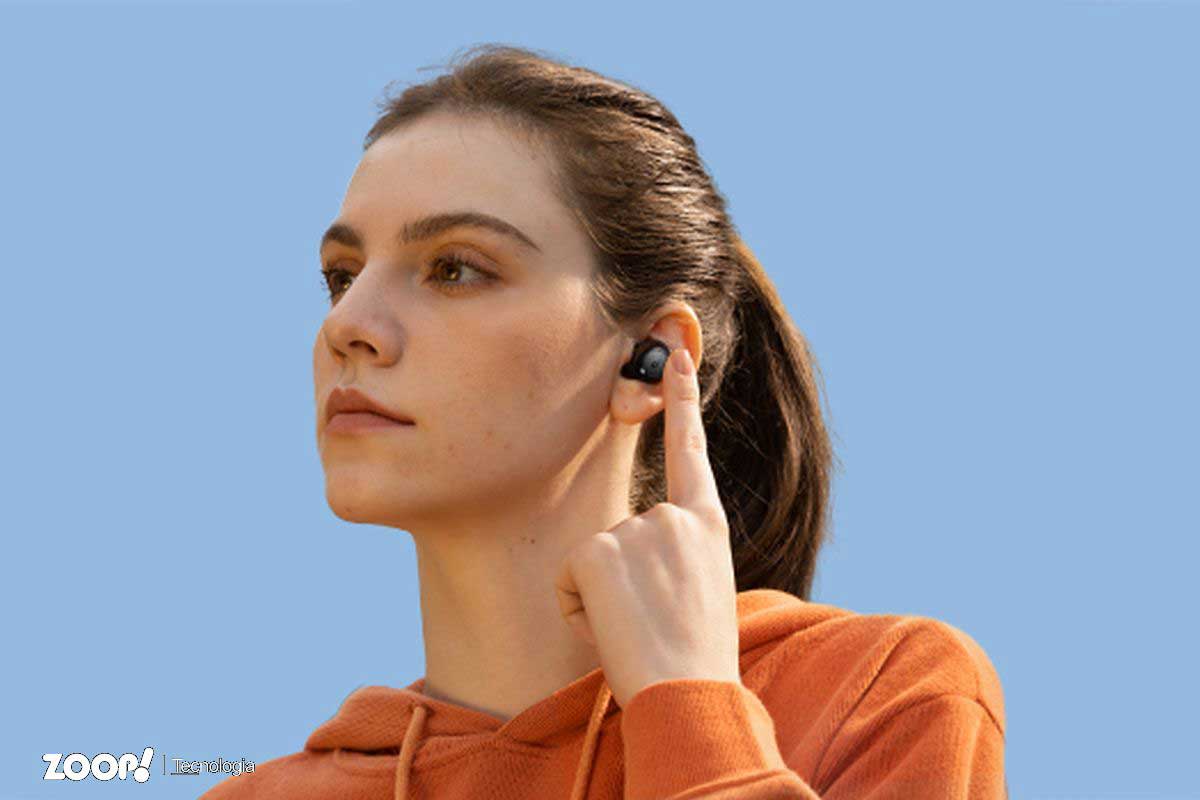 Uma mulher jovem usando fones de ouvido bluetooth ilustra o nosso artigo sobre: Os seis melhores fones de ouvido abaixo de R$ 500.