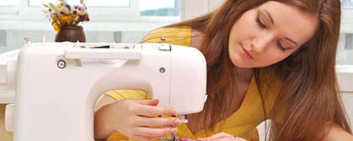 Como ganhar mais dinheiro? Uma mulher jovem usando uma máquina de costura moderna.