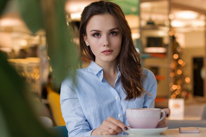 Uma mulher jovem numa cafeteria.