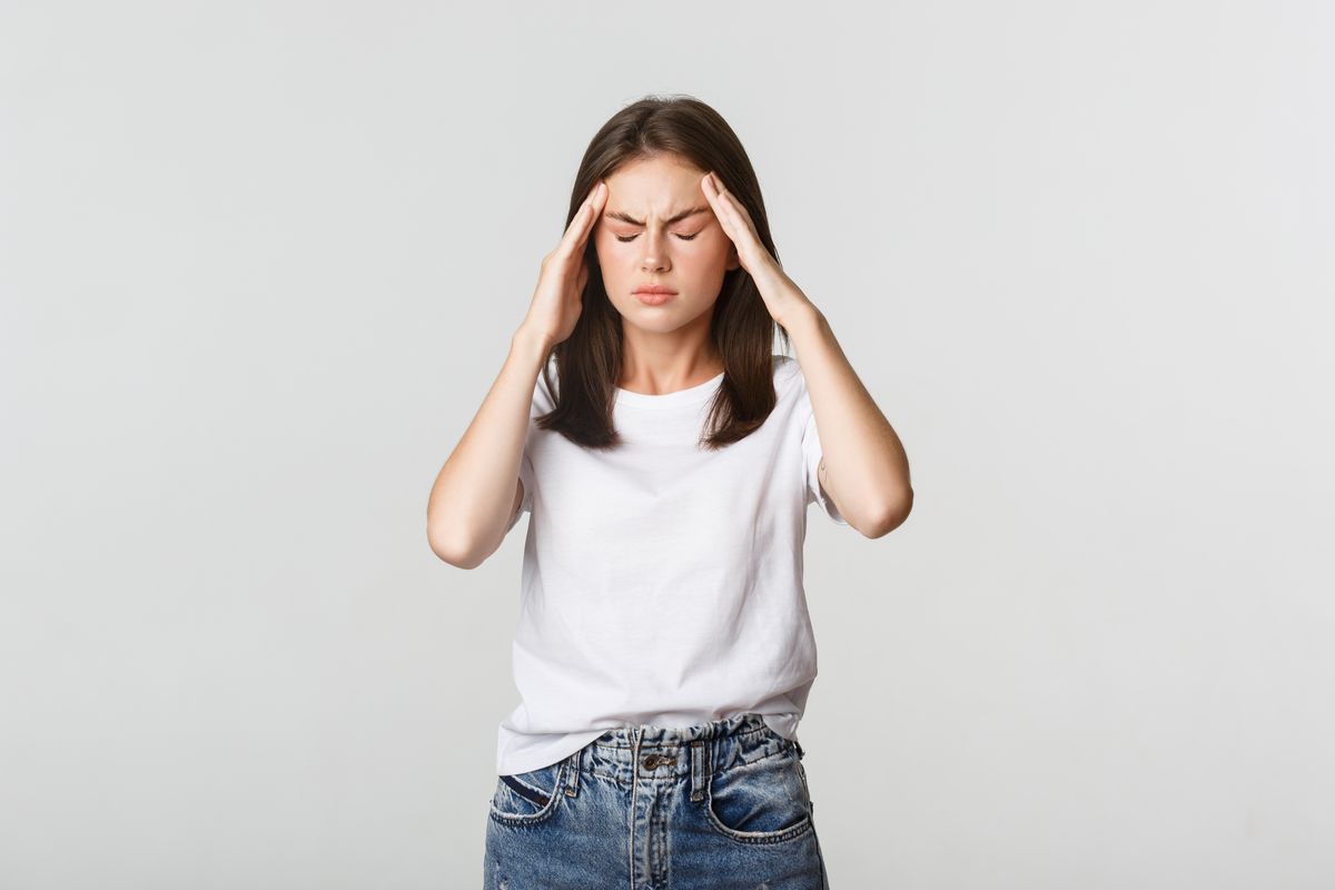 Uma mulher tocando a cabaeça demonstrando estar estressadas ilustra nosso artigo sobre: Três maneiras práticas para lidar com o estresse.