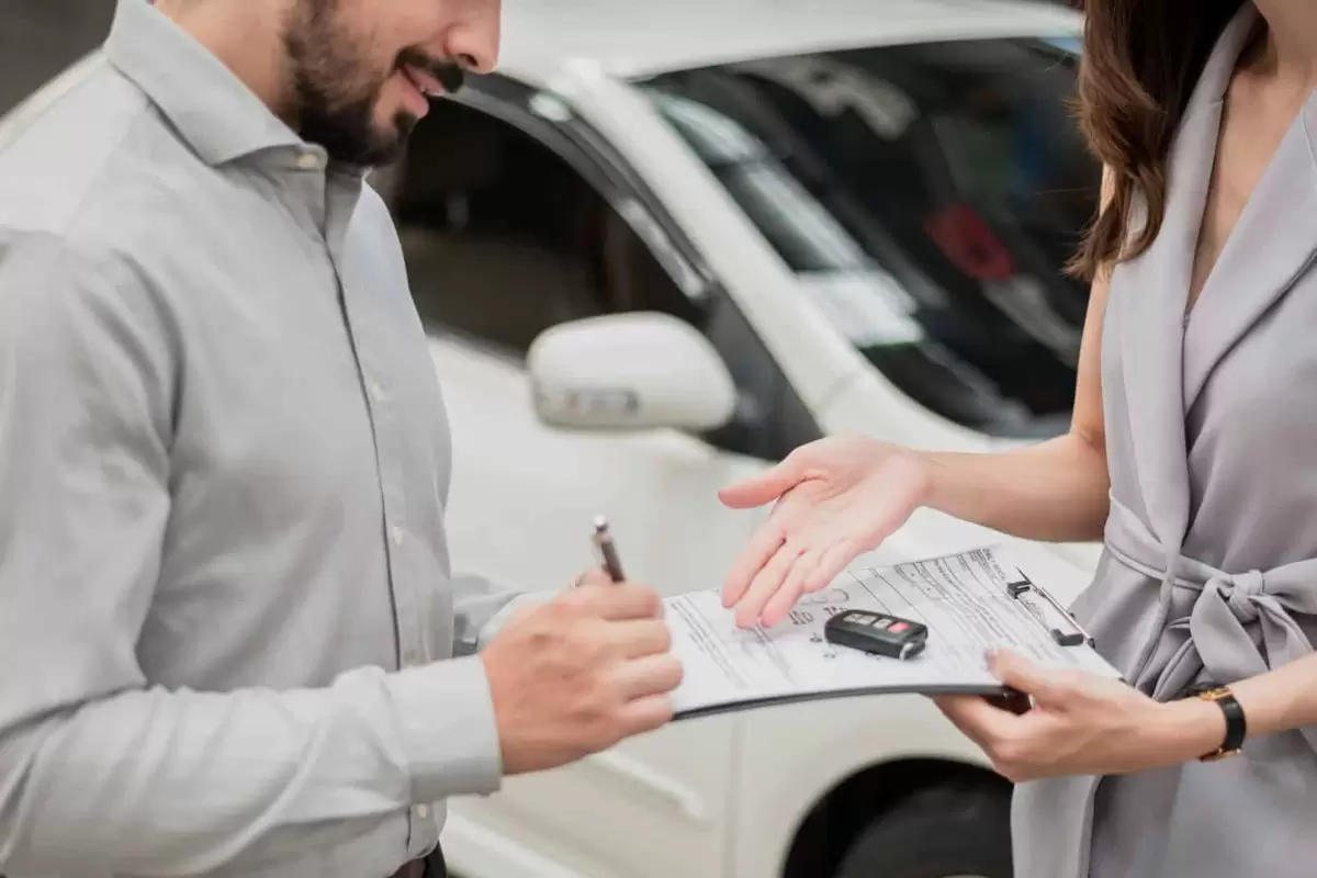 Cliente assinando contrato de seguro de carro.Imagem-via-ShutterStock