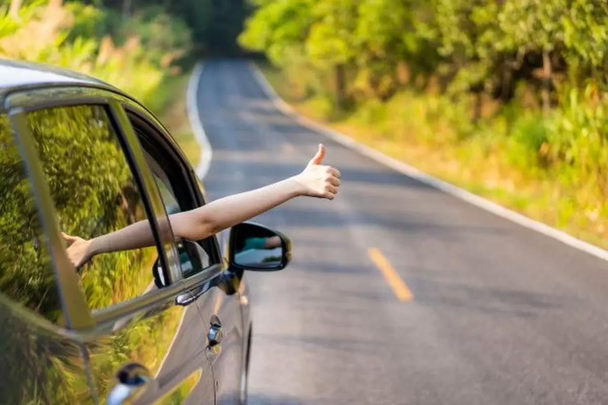 Uma pessoa estica o braço para fora do carro com o polegar levantado ilustra nosso artigo sobre: IPVA saiba tudo sobre o imposto.