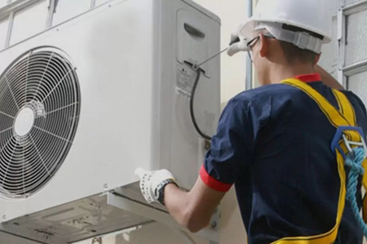 Técnico fazendo instalação de ar-condicionado ilustra nosso artigo sobre: Saiba o que está incluso na manutenção e instalação de ar-condicionado.