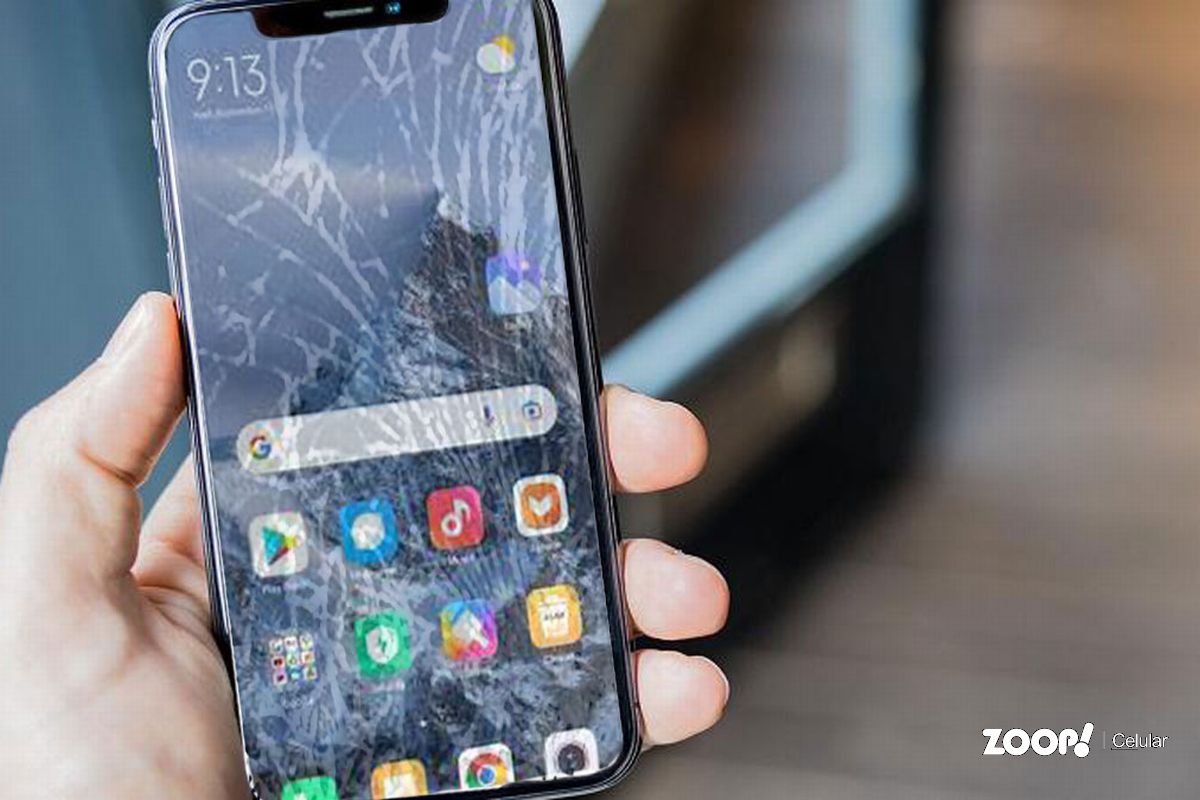 Uma pessoa mostra seu celular com a tela quebrada ilustra nosso artigo sobre: Efeito tela quebrada.