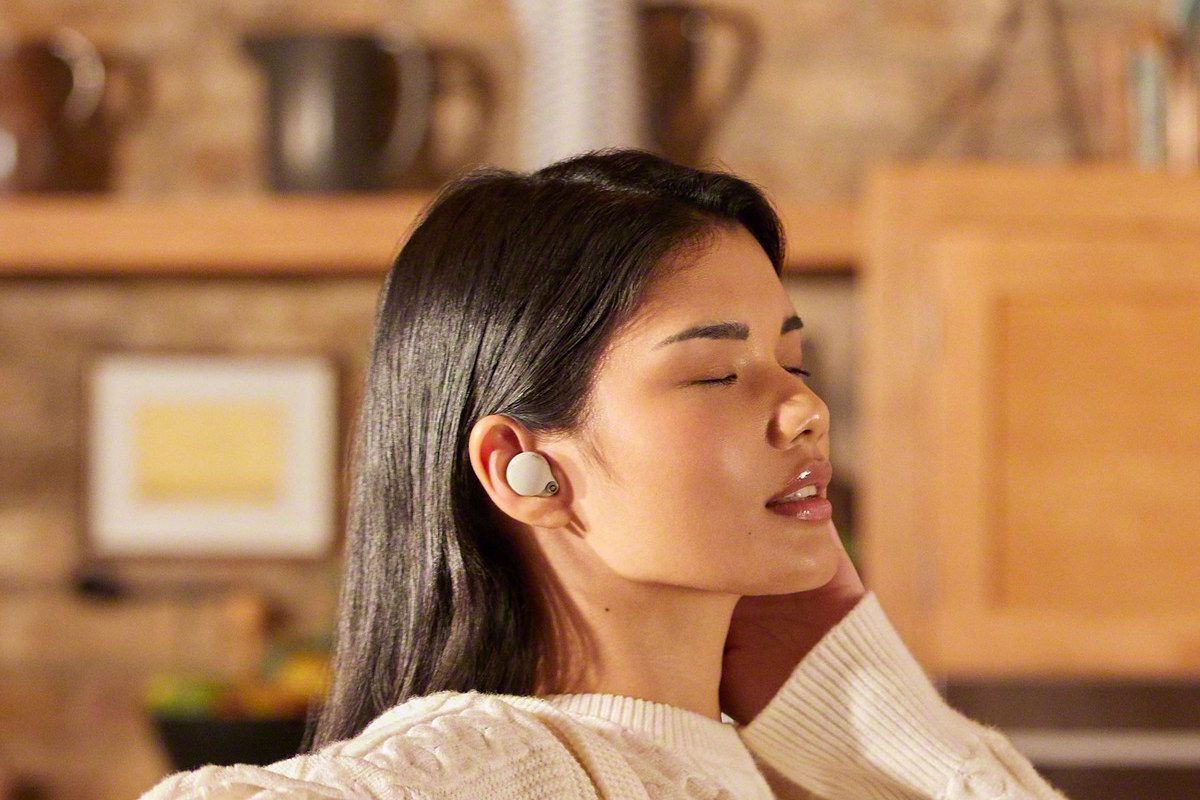 Uma mulher ouve música com os fones de ouvido Sony WF 1000XM4.