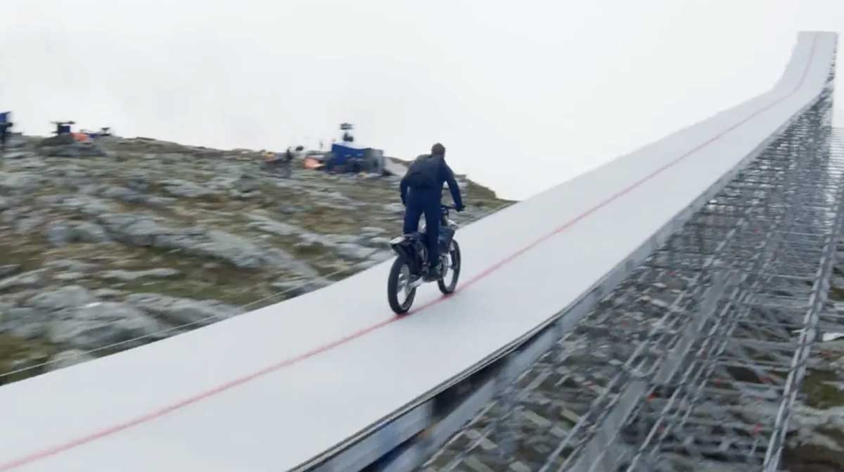 Tom Cruise acelera uma moto em direção ao penhasco. durante as filmagens de 'Missão: Impossível'