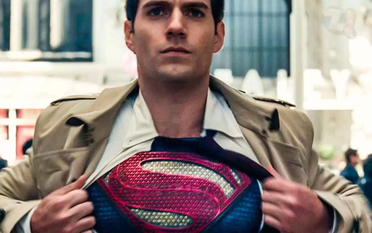 Henry Cavill abrindo a camisa para mostrar a roupa do Superman em filme da Warner. 