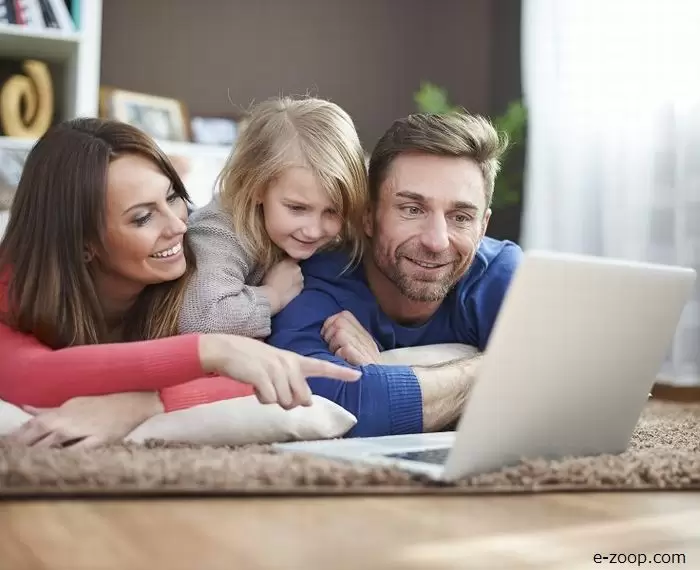 Um casal se divertindo mostrando a tela do notebook para a sua filha ilustras nosso artigo sobre: Como criar uma fonte de renda extra.