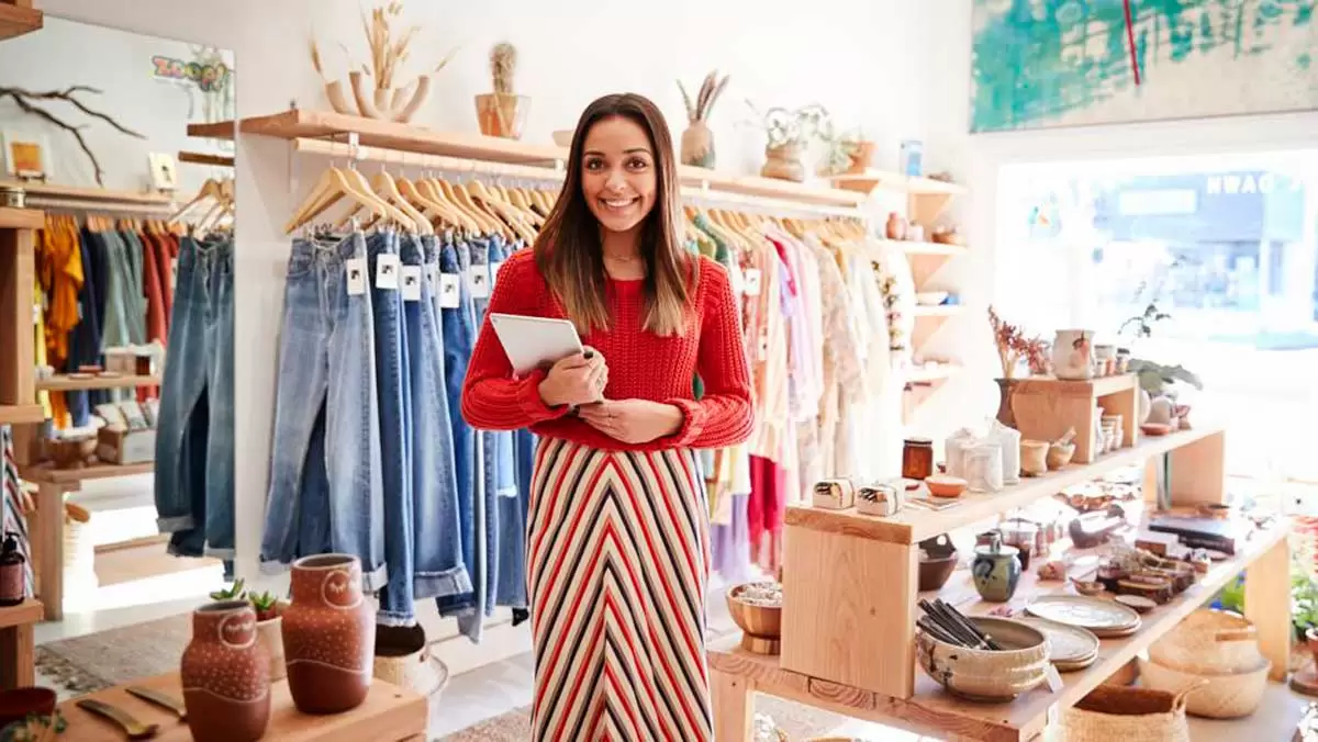 Uma empreendedora em sua loja de roupas. Uma empreendedora em sua loja de roupas.