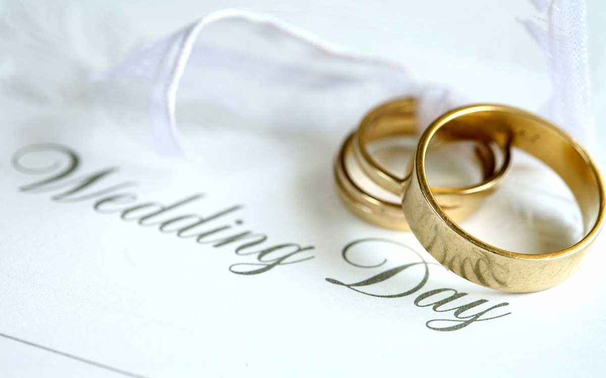 Alianças de casamento postas sobre um convite - (imagem ilustrativa)