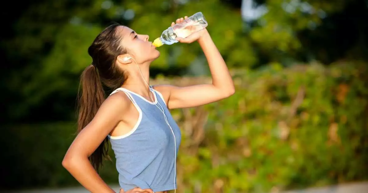 Uma mulher bebe água numa garrafa de plástico, ilustra nosso artigo sobre: Sonhar com beber água limpa.