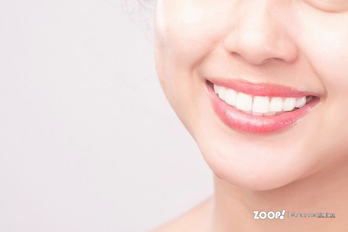 Uma mulher sorrindo com dentes muito brancos ilustra nosso artigo sobre: Sonhar com dentes.