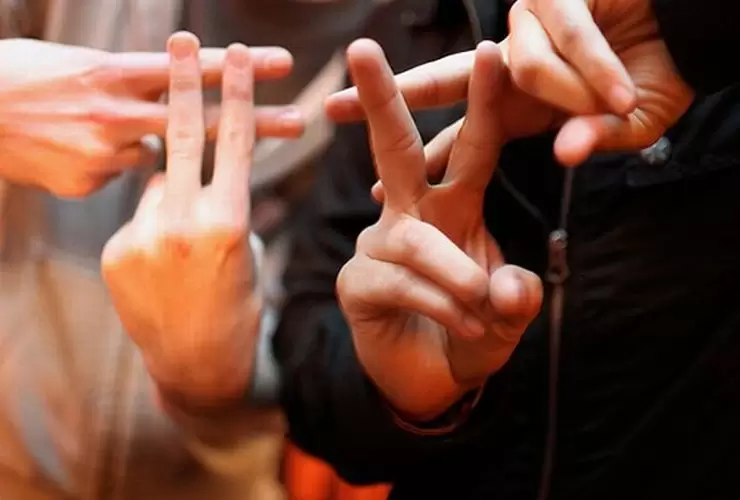 Duas pessoas fazendo o sinal de sustenido - cerquilha - com as mãos ilustra este artigo sobre: 'Como criar uma Hashtag''.