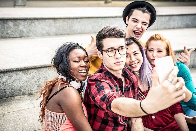 Comprar seguidores para Instagram. A imagem mostra Cinco amigos, jovens fazendo uma selfie para postar no Instagram.