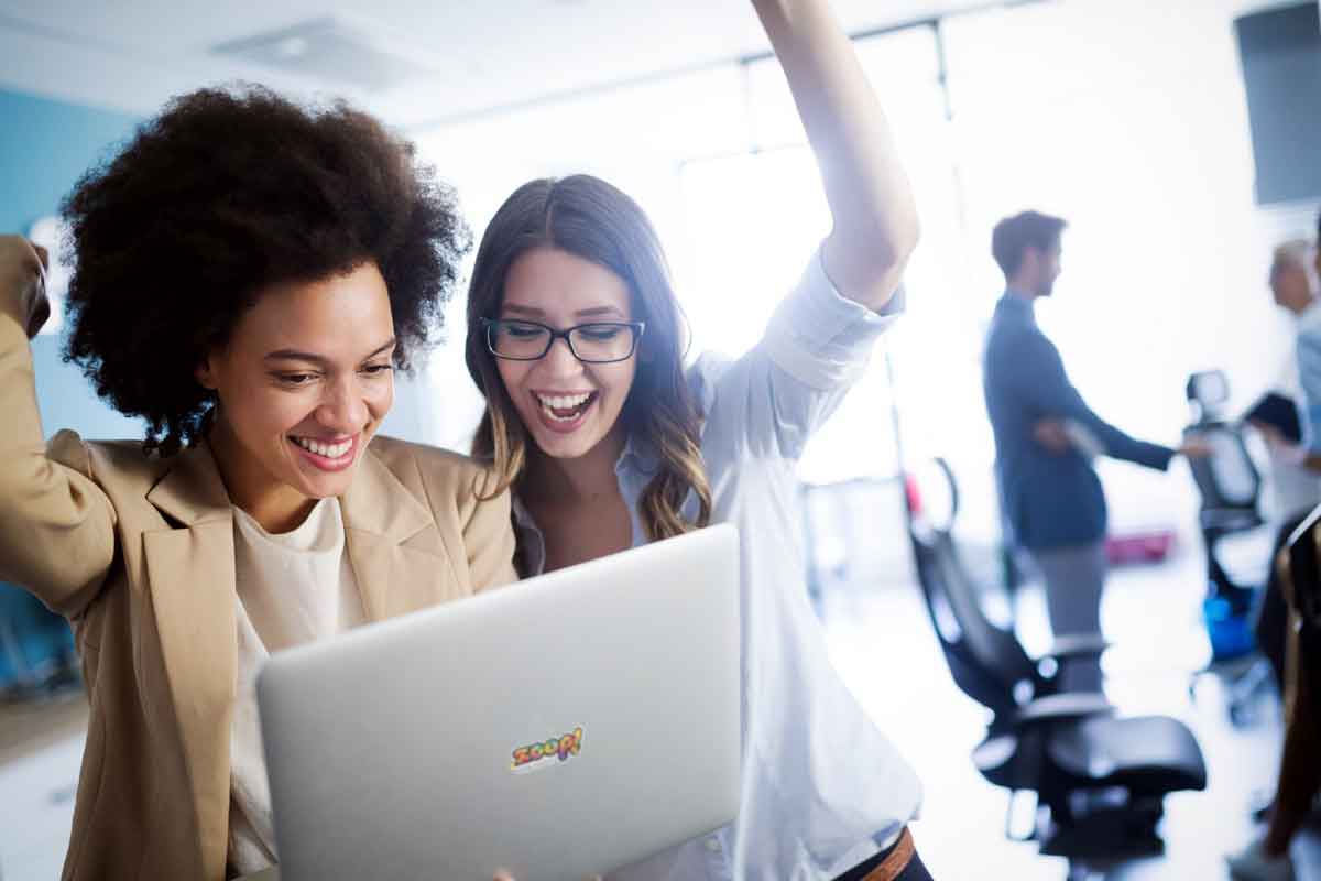 Duas mulheres jovens demonstrando felicidade ao vender um site.