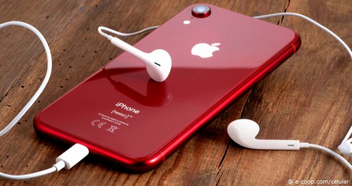Evolução do iPhone mostra um iPhone na cor vermelha com fones de ouvido intra-auriculares. 