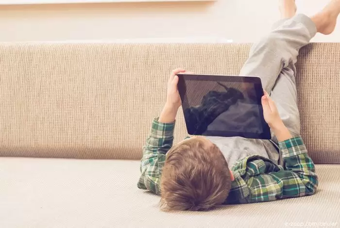 Um menino brincando com um tablet ilustra nosso artigo sobre: Diferenças entre smartphones e tablets.