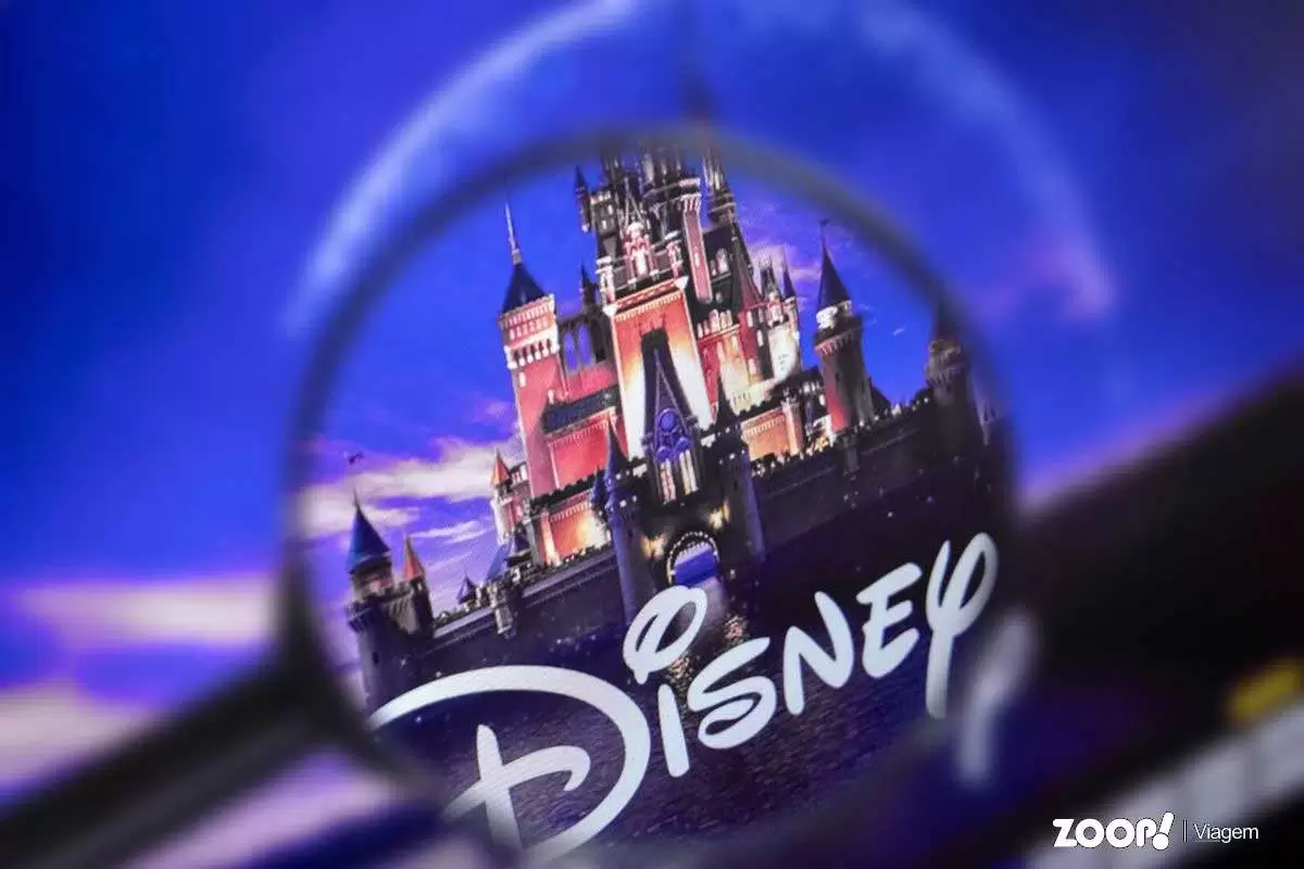  Uma montagem mostrando a marca Disney na frente de uma foto do castelo da Disney ilustra o artigo sobre como se tornar um agente de viagens Disney.