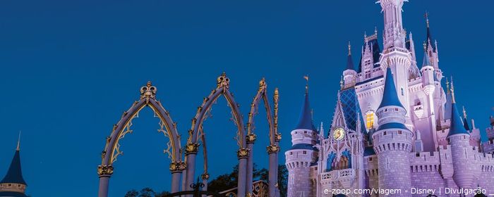 O castelo da Disney todo iluminado a noite.