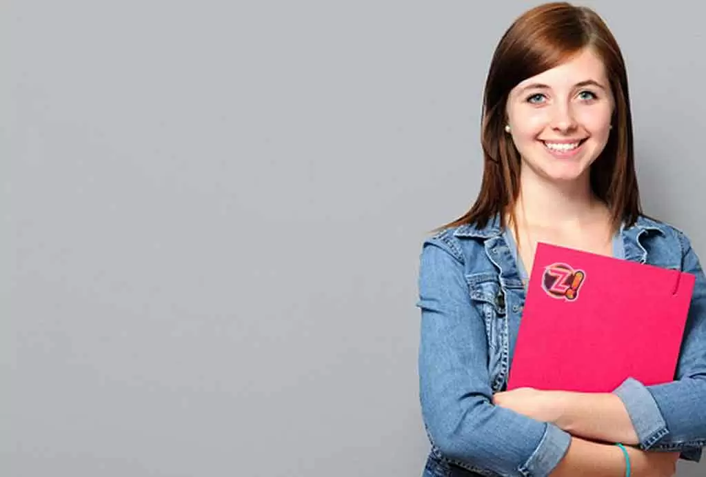 Uma mulher jovem sorri enquanto abraça uma pasta vermelha ilustra nosso artigo sobre: Como manter uma carreira profissional atualizada.