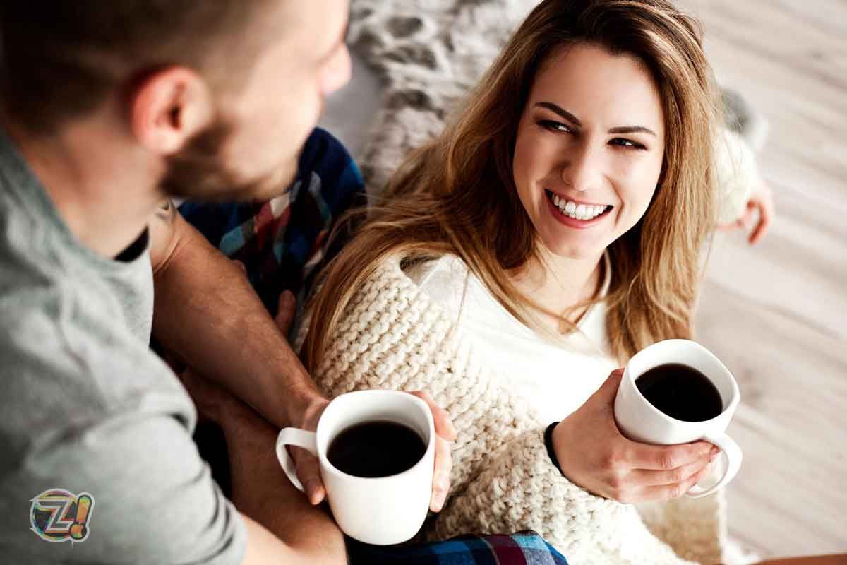 Um casal bebendo café e sorrindo.