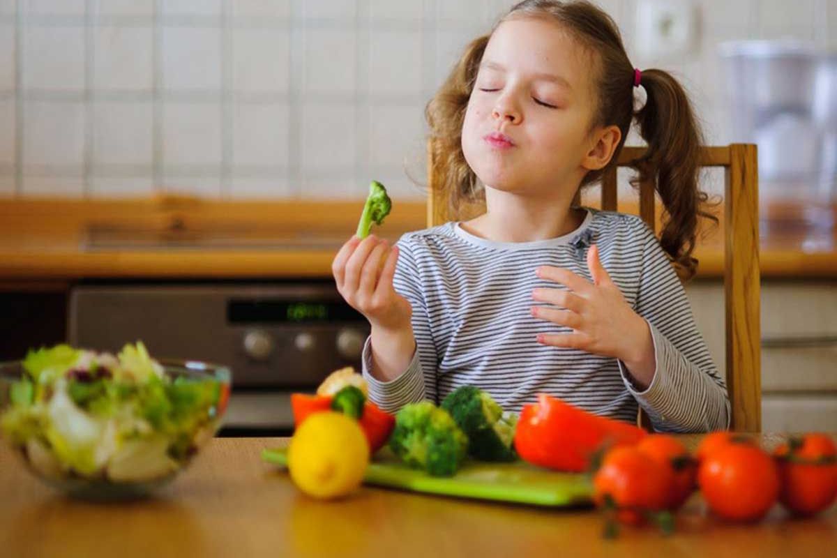 Nutrição para crianças: Uma criança comendo um pote de salada.