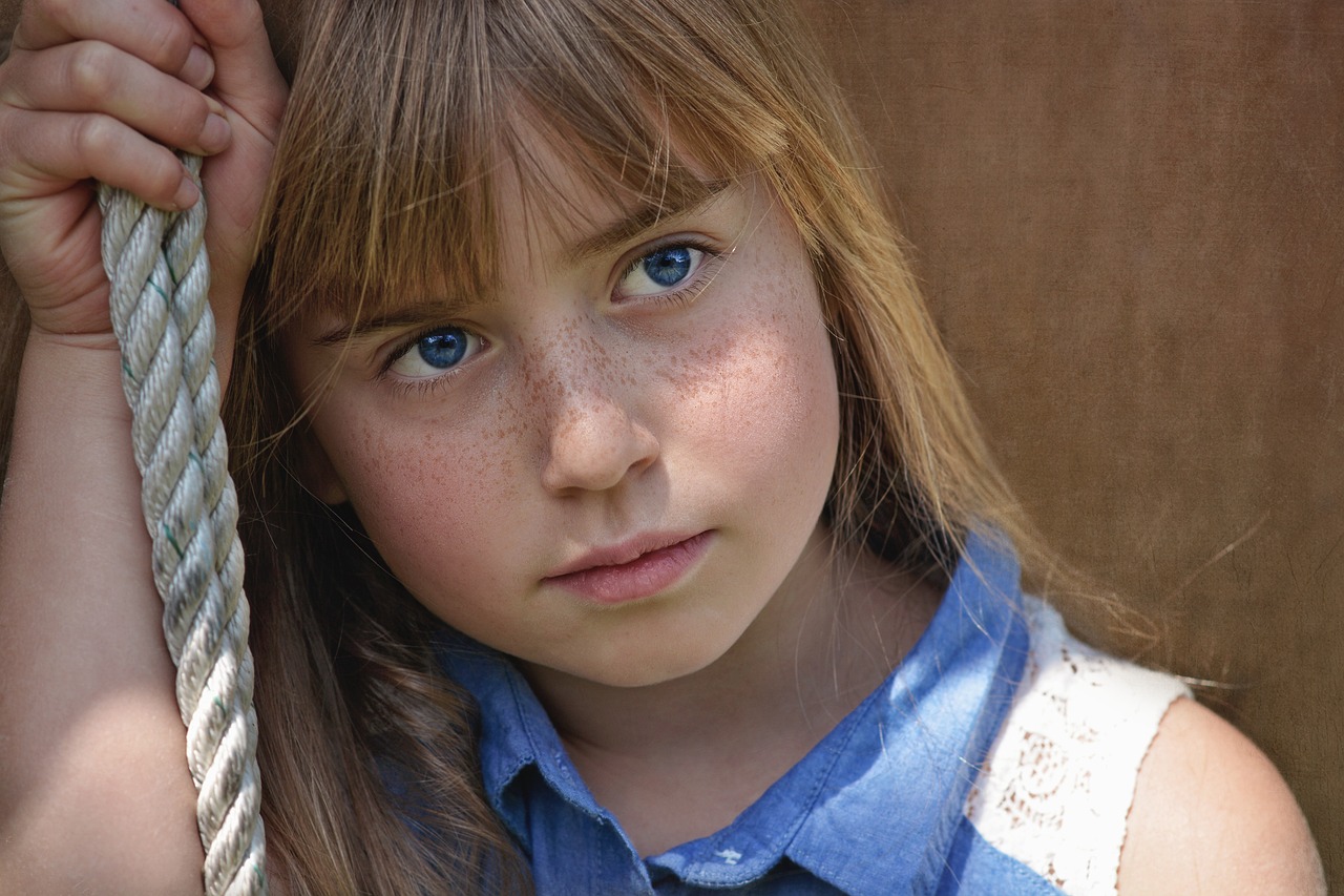 Uma menina posando para foto com olhar triste ilustra nosso artigo sobre: Os perigos da superproteção. 