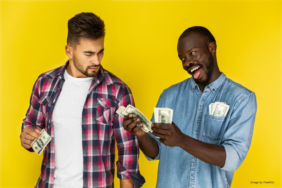 Dois homens trocando  dinheiro ilustram nosso artigo sobre: Como converter Kwanza Angolano para Reais