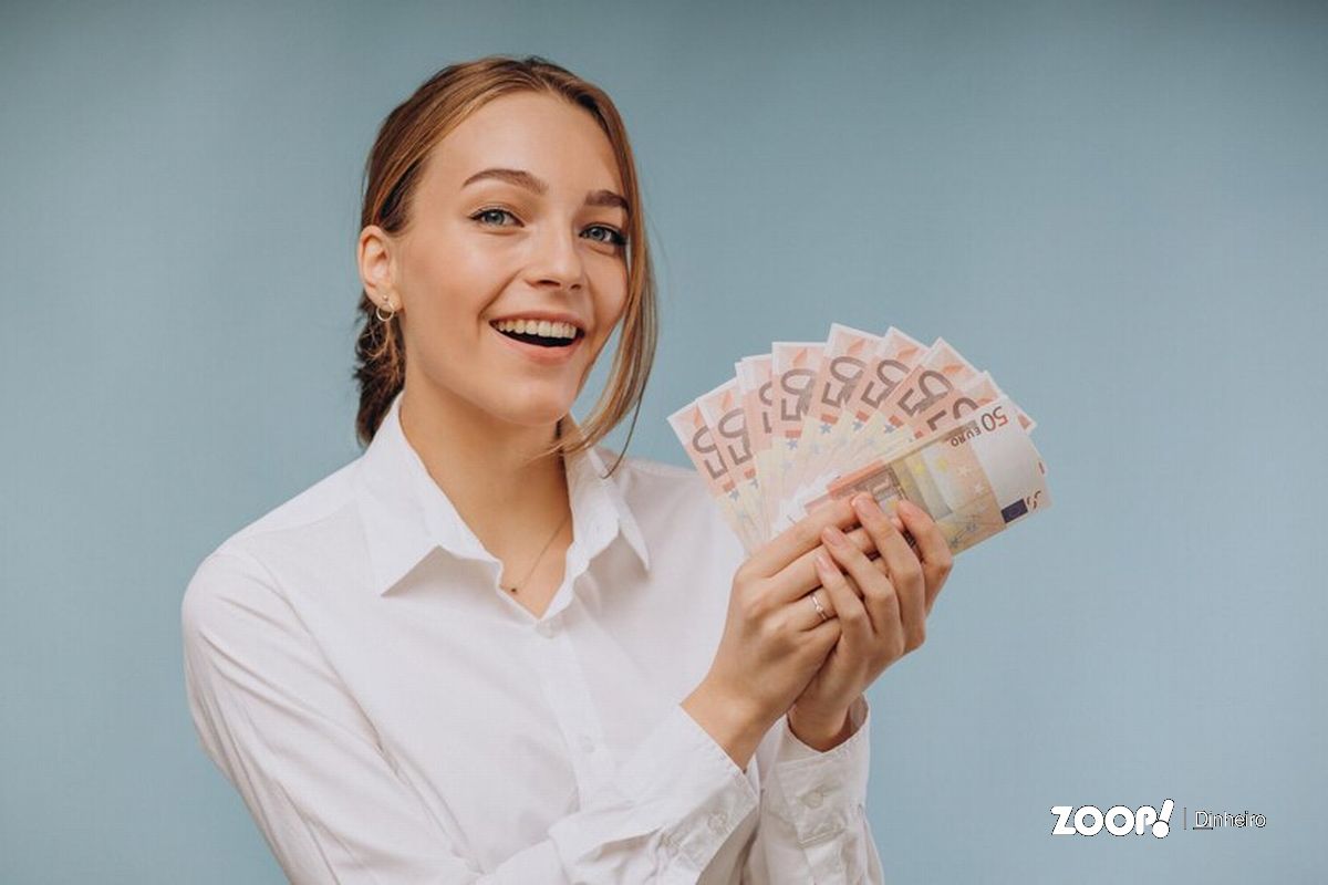 Dona de lotérica segurando maço de dinheiro ilustra nosso artigo sobre: Quanto ganha um dono de lotérica por mês?
