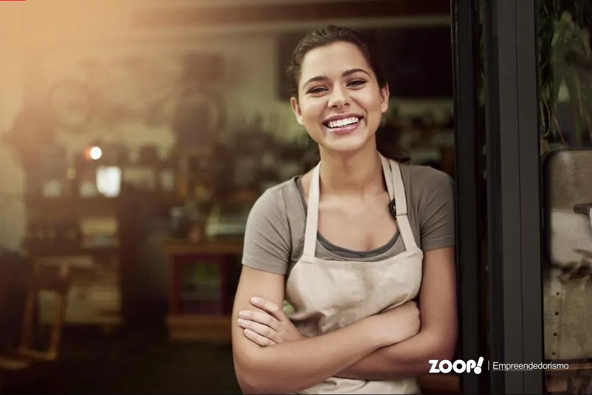 Dona de pequena empresa posando sorridente para uma foto ilustra nosso artigo sobre presença online para empresas de pequeno porte em Chapecó. 