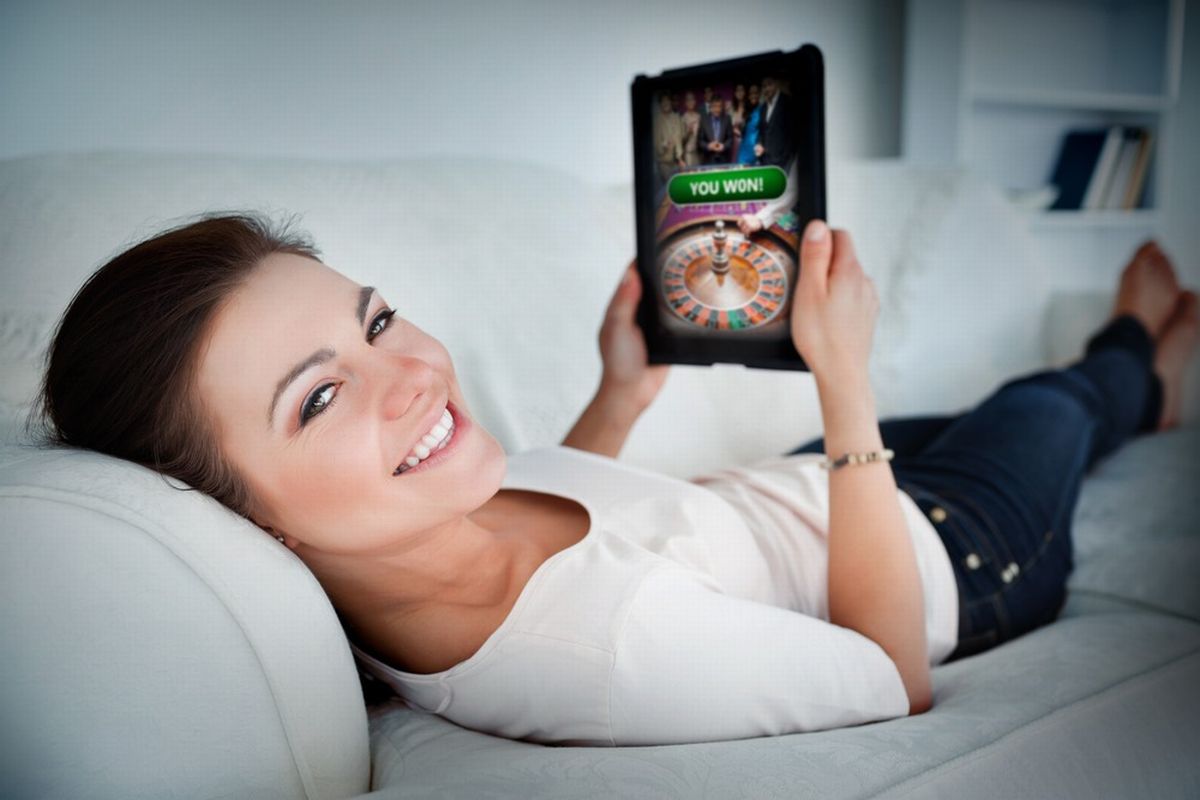 her sorridente deitada no sofá faz aposta online usando um tabletilustra nosso artigo sobre:  KTO é uma plataforma de jogos legal e verificada no Brasil.
