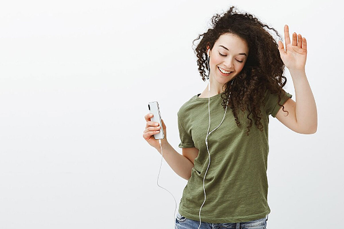 Uma mulher jovem ouvindo música com fones de ouvido ilustra nosso artigo sobre; a música controla o corpo: Humanos sincronizam piscadas e ondas cerebrais ao ritmo de uma canção. Crédito da imagem: freepik.com