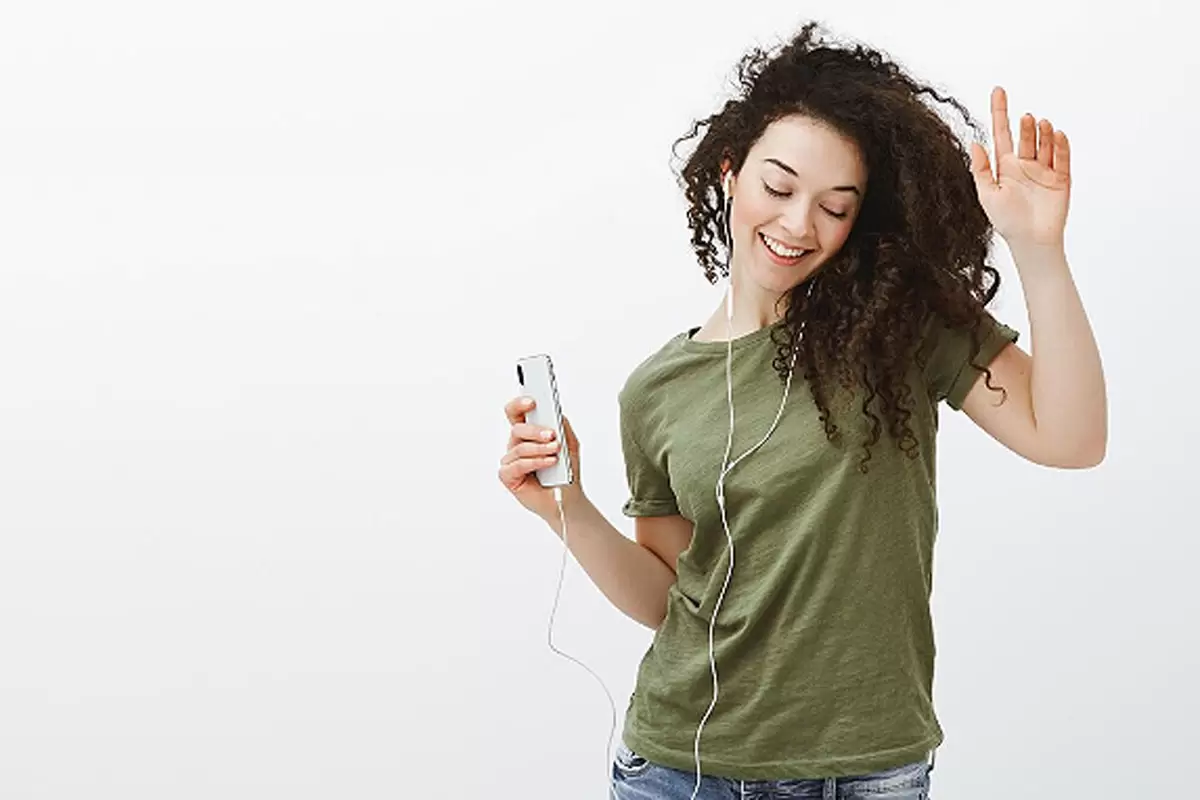 Uma mulher jovem ouvindo música com fones de ouvido ilustra nosso artigo sobre; a música controla o corpo: Humanos sincronizam piscadas e ondas cerebrais ao ritmo de uma canção. Crédito da imagem: freepik.com