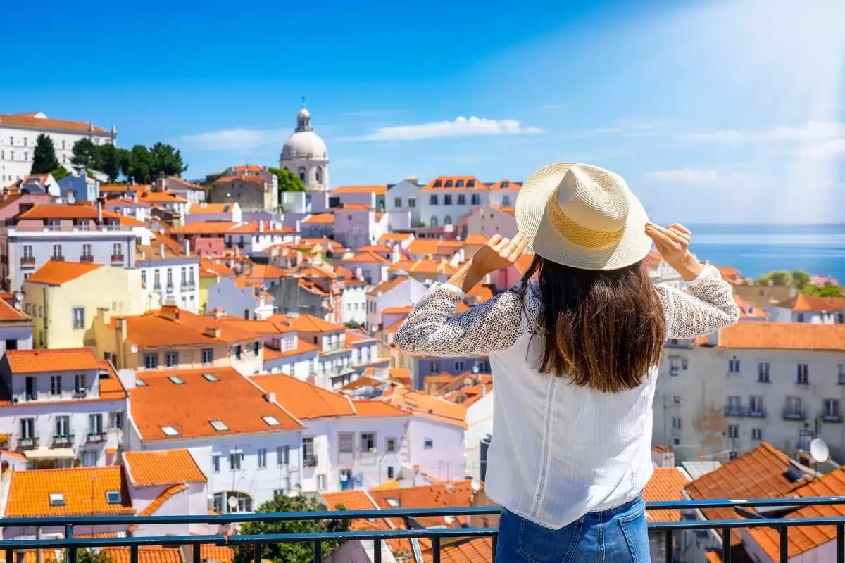 Uma mulher apreciando a vista da cidade em Portugal ilustra nosso artigo sobre: Vaga de Emprego em Portugal: Onde Encontrar e Como se Candidatar