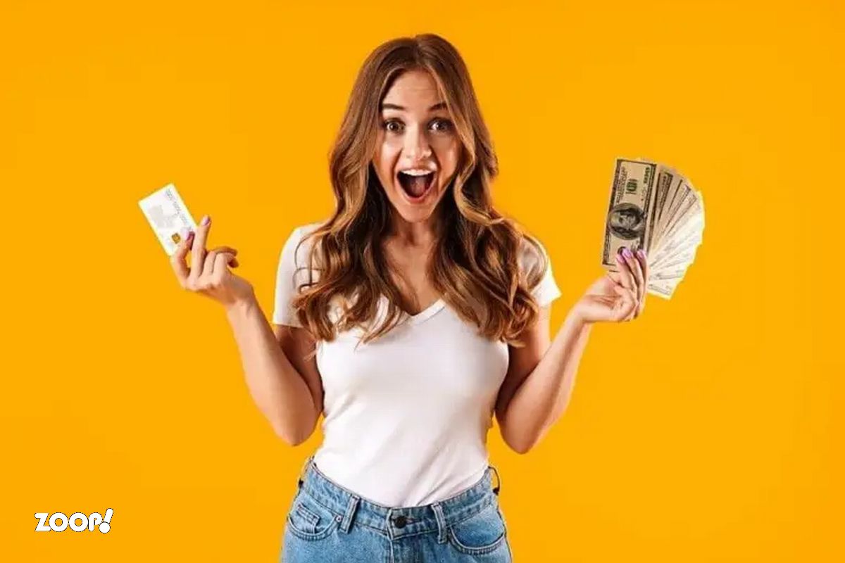 Uma mulher sorridente segura um maço do dinheiro ilustra nosso artigo sobre: Os signos que vão enriquecer em 2024: veja se o seu é um deles.