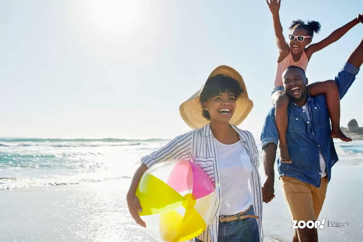  Uma família em férias na praia ilustra nosso artigo sobre: Férias em família: conheça os melhores destinos.