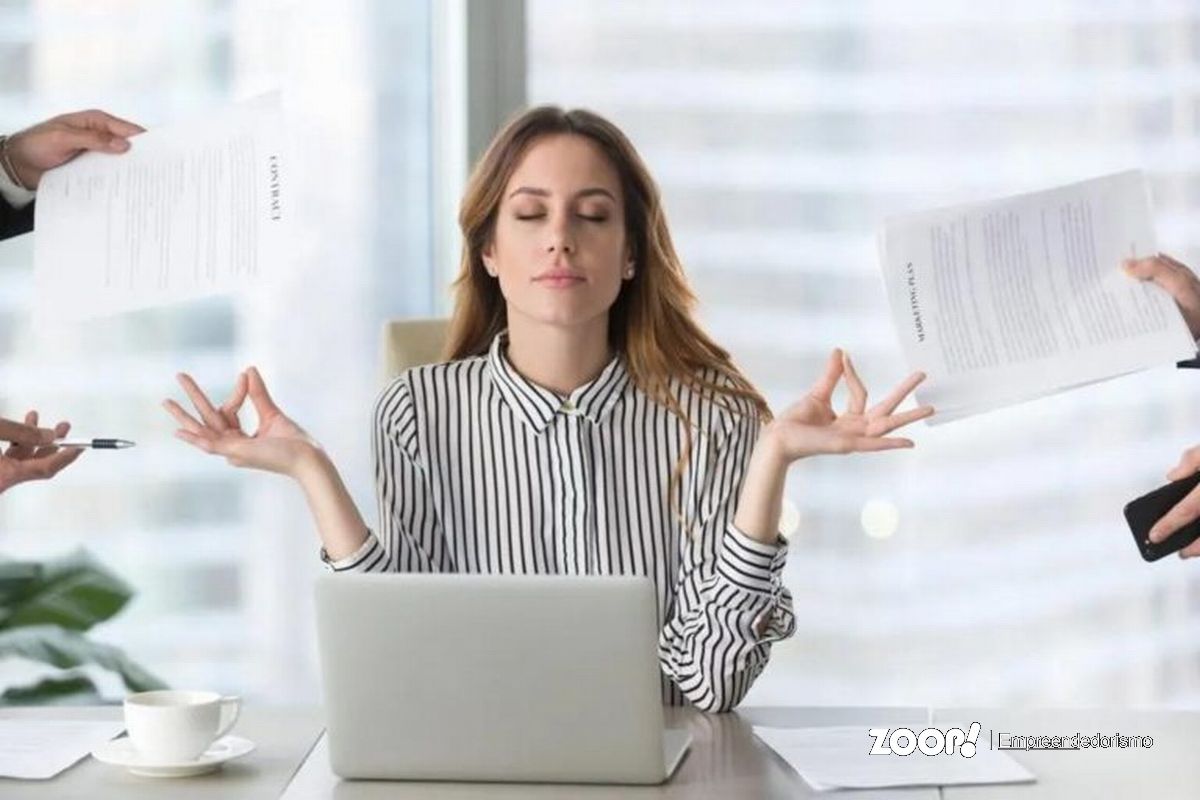 Uma mulher em estado zen no ambiente de trabalho ilustra nosso artigo sobre: Como criar uma rotina equilibrada com a ajuda da tecnologia.